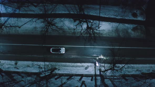 Aerial Top Down View of Illuminated City Road at Night with Car