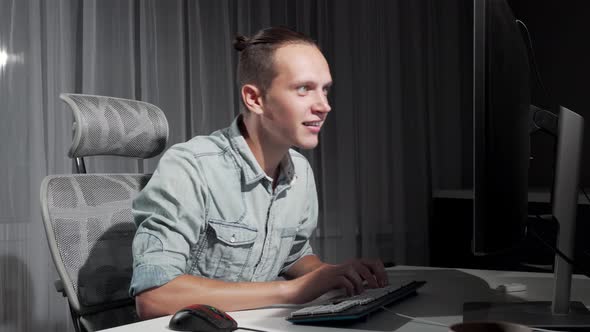 Happy Man Dancing in His Chair in Front of Computer Celebrating Success alt