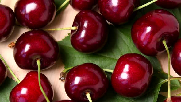 Ripe sweet cherry rotating top view on wooden background alt