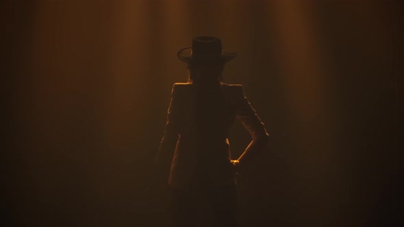 Attractive Sexy Woman Dancing Flamenco Elements in a Dark Studio in the Rays of Light. A Dancer in a alt
