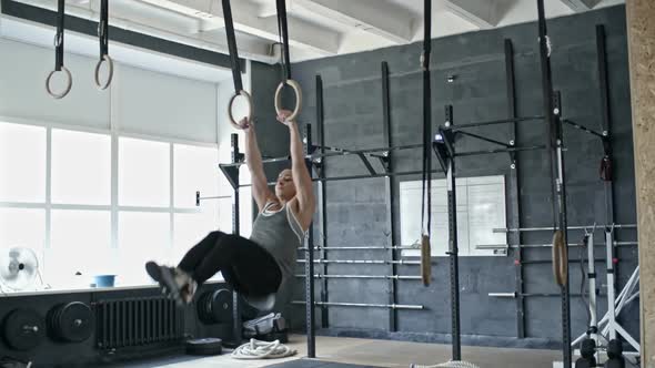 Muscular Woman Exercising on Rings alt