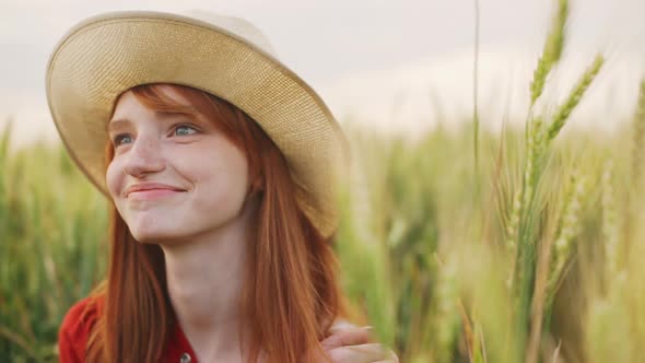 Close Up of Beautiful Redhead Woman with Blue Eyes Farm Girl Standing on Wheat Field and Smiling