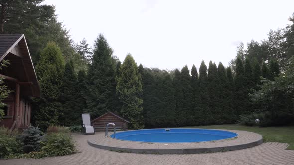 Relaxation Yard of Wooden House with Swimming Pool and a Sun Lounger Next to It alt