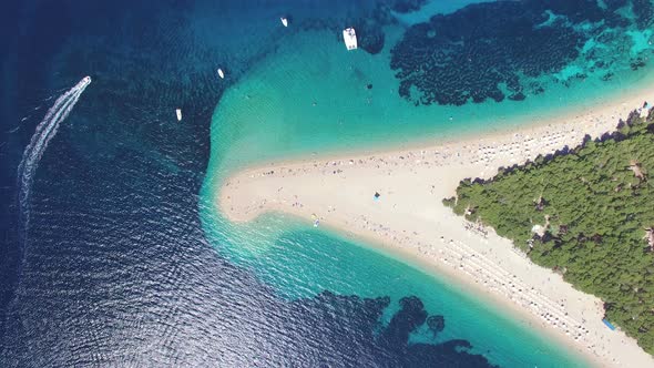 Motorboat passing the sandy beach Zlatni rat on the island of Brac, Croatia alt
