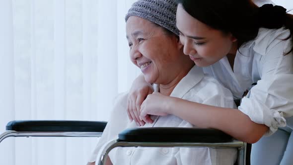 Young daughter encourages and comforts a mother with cancer during hospitalization. alt