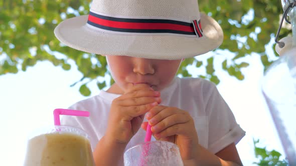 Portrait of Child Drinking Fresh Juice Outdoor. Refreshing Drink with Ice. Summer Drinks. Traveling