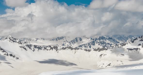 Air Flight Through Mountain Clouds Over Beautiful Snowcapped Peaks of Mountains and Glaciers alt
