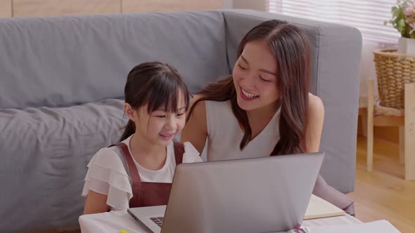 Asian young mother and her daughter have video call conference with family having fun together alt
