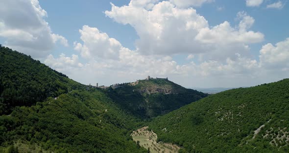 Aerial View Flying Above Rural Town or Village or City of Assisi Castle. Backward Establisher alt
