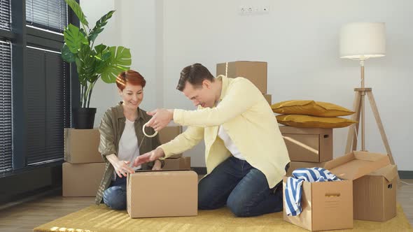 Caucasian Man Using Scotch Packing Carton Parcel Box at Home Preparing Family Belongings to Moving