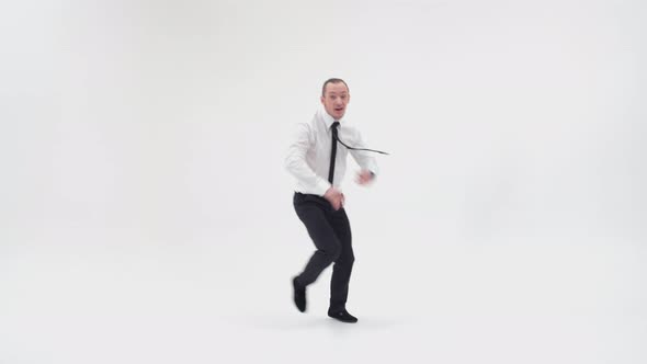 A Cheerful Office Worker Is Dancing a Break Dance. The Businessman Stands on One Hand with His Knees alt