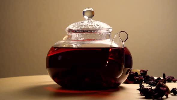 Spinning Teapot with Red Hibiscus Tea on Table