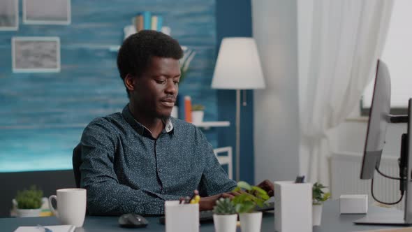 African American Manager Working From Home Sipping Coffee and Typing on the Computer alt