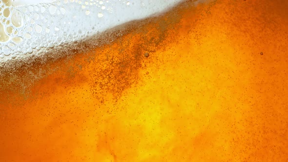 Super Slow Motion Detail Shot of Rippling Beer Bubbles and Foam in Glass at 1000Fps alt