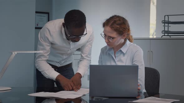 Diverse Business People Using Laptop Computer Working Together at Desk in Modern Office alt