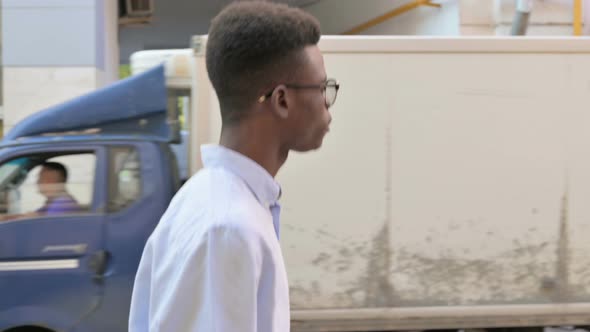 Side View of African Man Walking on the Street alt