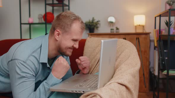 Young Adult Man at Home Office Use Laptop Pc Typing Browsing Say Wow Yes Found Out Great Big Win alt