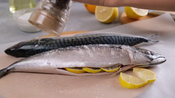 Cooking fish. The chef sprinkles the raw fresh fish with pepper.