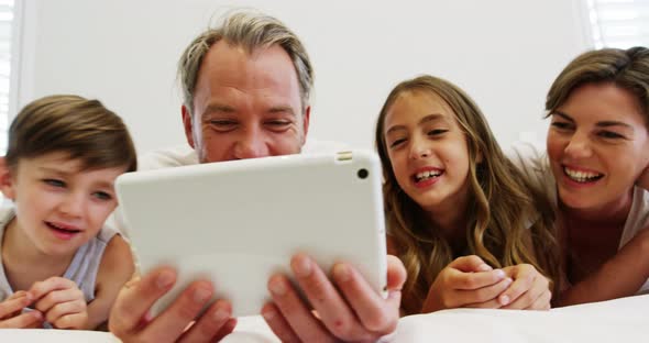 Family using digital tablet in bedroom alt