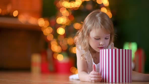 Cute Little Girl opens a Christmas present