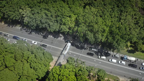 The Train Passes the Railway Crossing the Cars Stopped in Front of the Barriers  Aerial Drone Shot alt