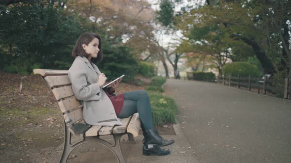 Girl With A Tablet In The Park