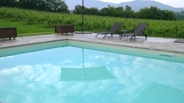 Reflection of beach umbrellas in a blue pool at a luxury resort in Italy, Europe. alt