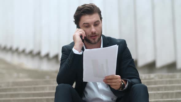 Businessman Talking on Smartphone in City. Man Throwing Documents on Floor alt