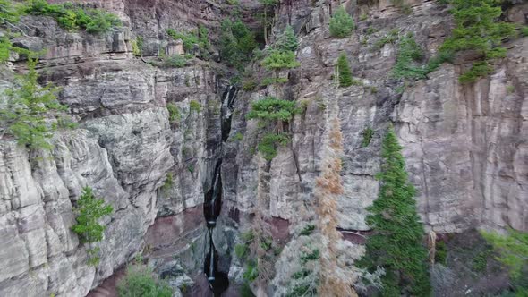 Aerial Into Large Canyon with Tiers of Waterfalls in Background alt