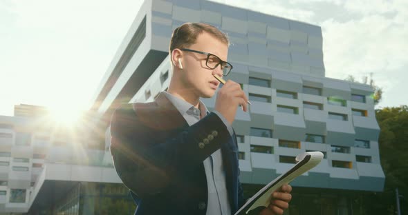 The Businessman Is Thinking and Writing with a Pen