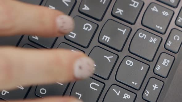 Hands Writing Ond a Keyboard of a Laptop or a Notebook in Home Office