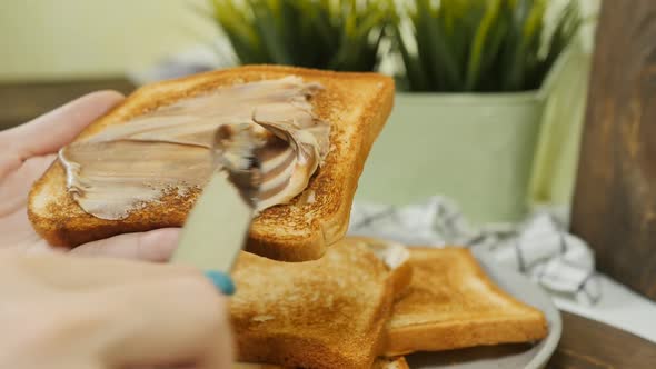Female Hands Spread Bread Toast with Nut Chocolate Paste