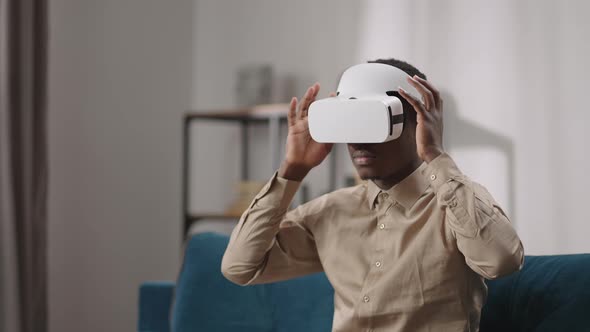 Young Black Man is Putting Headmounted Display Off Medium Portrait of Guy with Modern Gadget alt