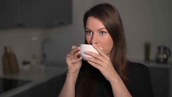 A Young Woman is Holding a Cup of Tea or Coffee for Breakfast