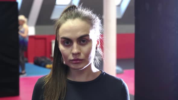 A Young Pretty Woman Trains Her Punches at the Punching Bag alt