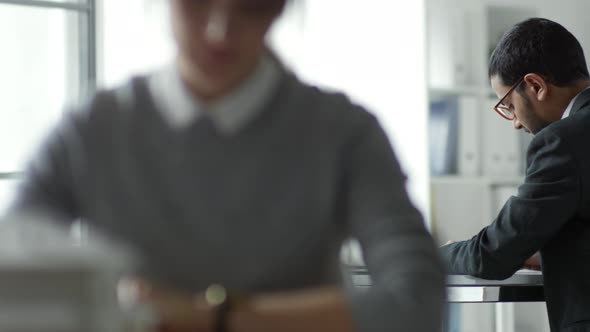 Office Worker Using Gadget at Desk alt