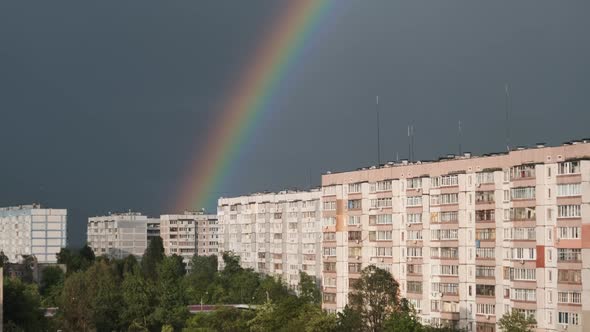 Huge Rainbow in the Cloudy Sky Above the Houses in City alt