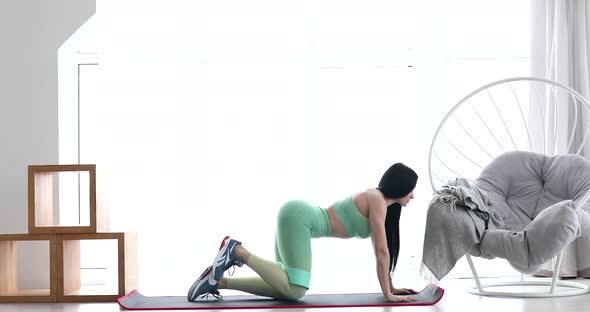 Resistance band fitness girl in sportswear doing leg workout floor exercises. alt