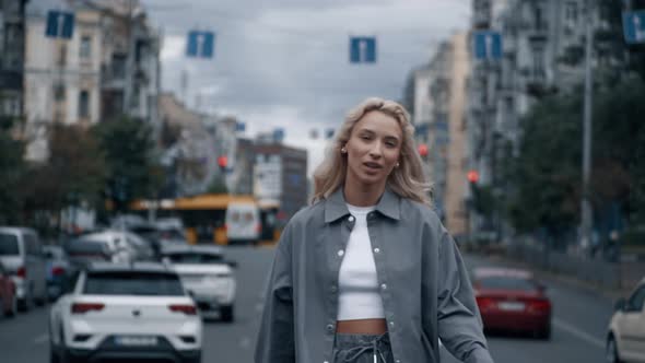 Beautiful Woman Taking Walk in Cityscape Near Road with Driving Cars alt