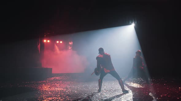 Sword fight in the circus arena with beautiful red lighting in the fog, confetti flying, slow motion
