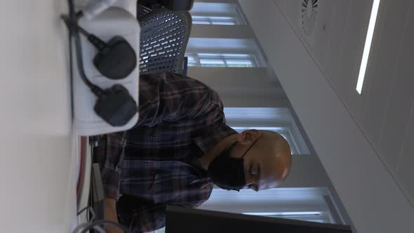 Smart Casual Adult Male Wearing Face Mask Using Computer In Office. Low Angle, Vertical Video, Locke alt