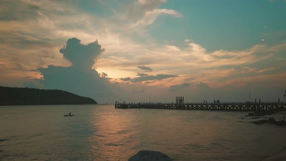Bay and beach near the pier with small island view during sunset alt