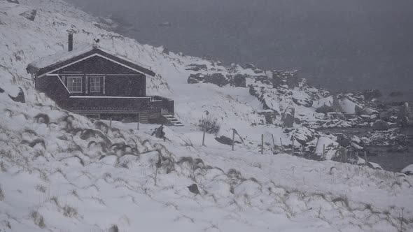 House on the Rocky Shore of the Fjord and Snowfall