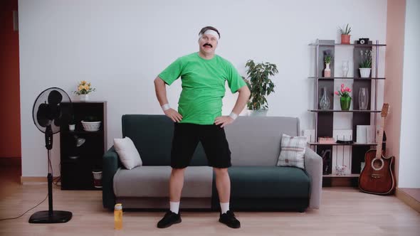 The mustachioed young man is exercising in his home.