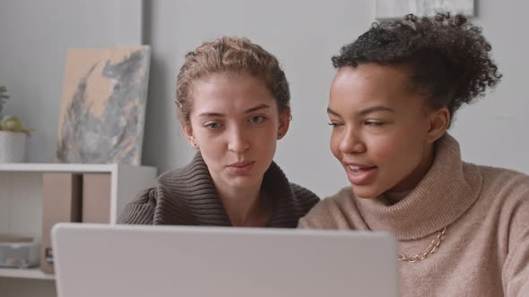 Young Women Discussing Presentation on Laptop alt