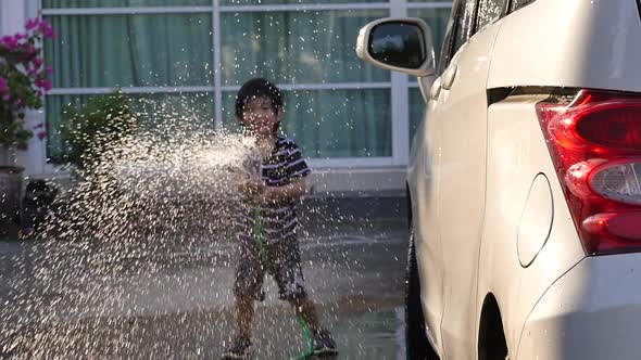 Asian Child Washing Car In The Garden On Summer Day Slow Motion 2 alt