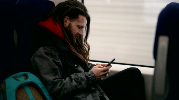 Hipster is Travelling By Train and Using App and Message Chat in Cellphone Internet Addiction alt