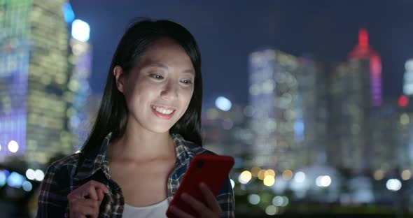 Woman check on mobile phone at outdoor in city at night alt
