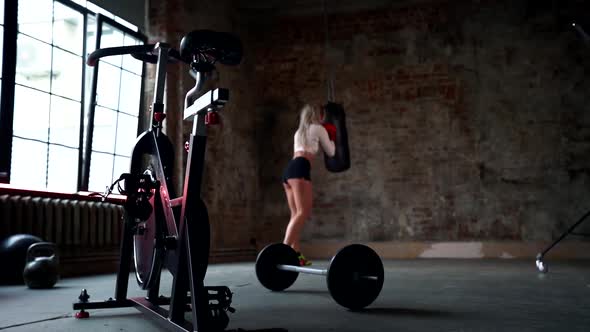 Blonde Woman Is Practicing Box Fight in Gym, Punching Bag By Hands, Training alt