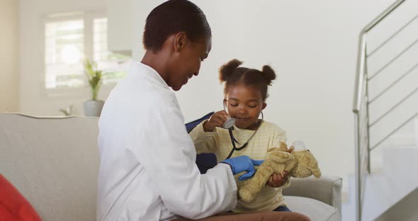 African american girl using stethoscope and smiling during medical home visit alt